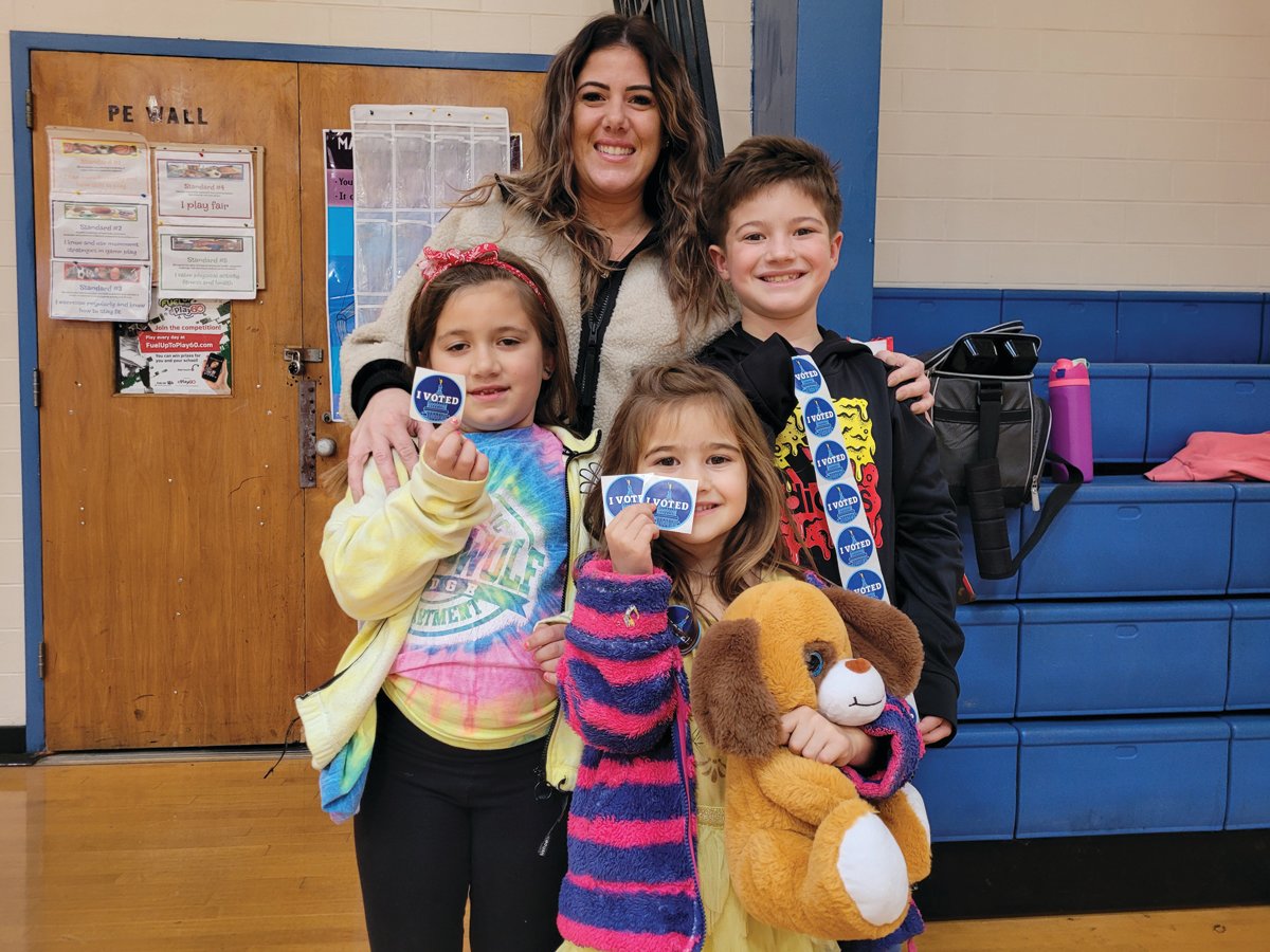 THEY VOTED: Johnston voter Mellissa Ritz brought her three children, Grace, 5, Gabriella, 7, and Frank, 9, with her while she voted at the Ferri Middle School on Tuesday. Frank scored a whole bunch of “I VOTED” stickers. “They just gave them to me,” he said.